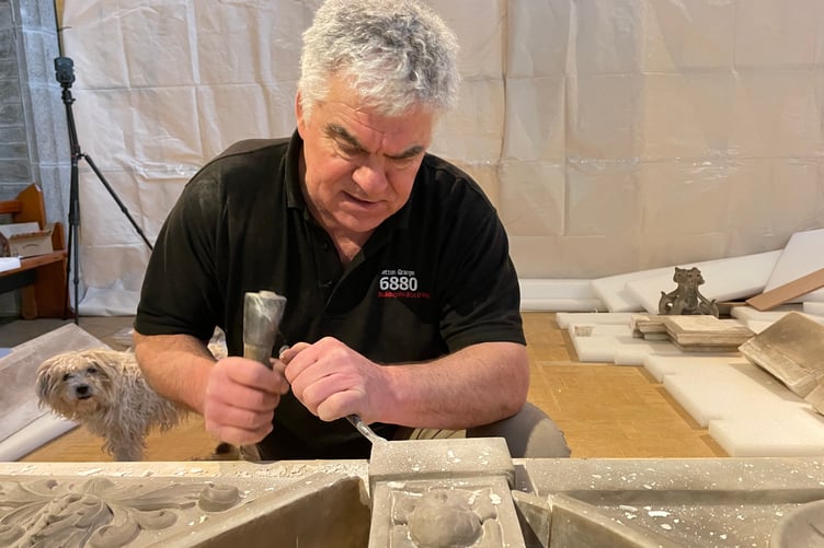 Philip Chatfield preparing the top of the altar for reattachment, while being observed by a parishioner’s dog.