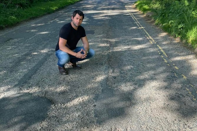 Cllr Leigh Frost inspecting the road surface on Old Callywith Road