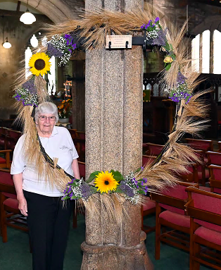 Yvonne Tew proudly stands alongside the display entitled ‘New Lives’ created by Maxine Durston.