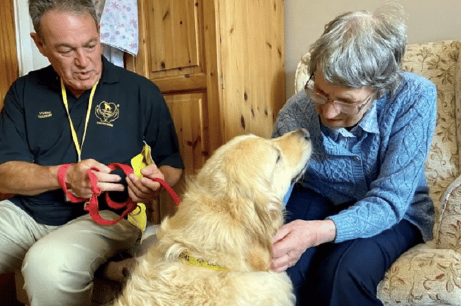 Bailey, the Golden Retriever, who volunteers from Therapy Dogs Nationwide, with his owner, Grant meeting residents