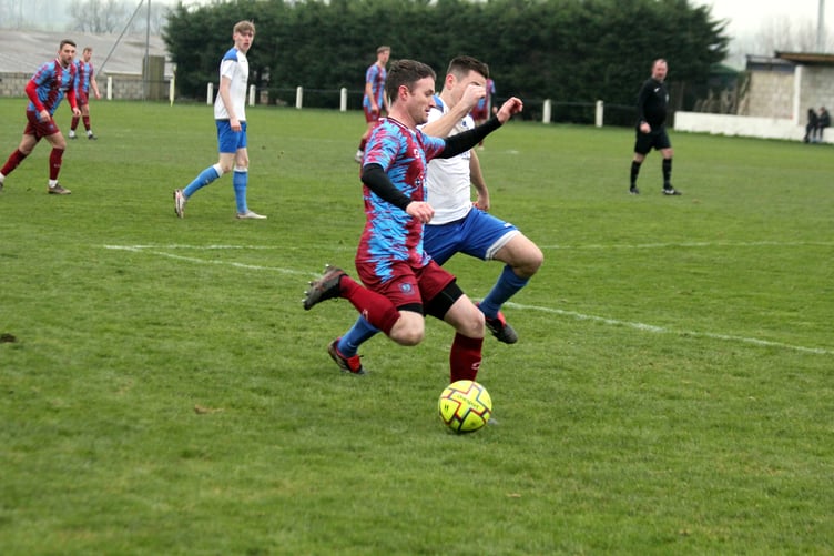Launceston's Andy Watkins takes on Camelford left-back Jake Chafer at Pennygillam on Saturday.