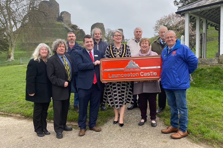 Members of the Launceston Railway Circle stood alongside, Luke Farley (GWR chief of staff), Cllr Helen Bailey (mayor) and Councillor Nicola Gilbert (deputy mayor) with the Launceston Castle sign