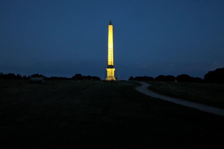 The Bodmin Beacon memorial obelisk lit up yellow