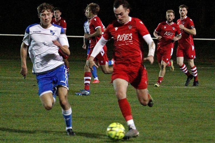 Bude Town midfielder Ruan Tape, who received praise from boss Steve Hackett for his second half performance, looks to get away from Camelford goalscorer Olly Taylor. Picture: Chris Pointer