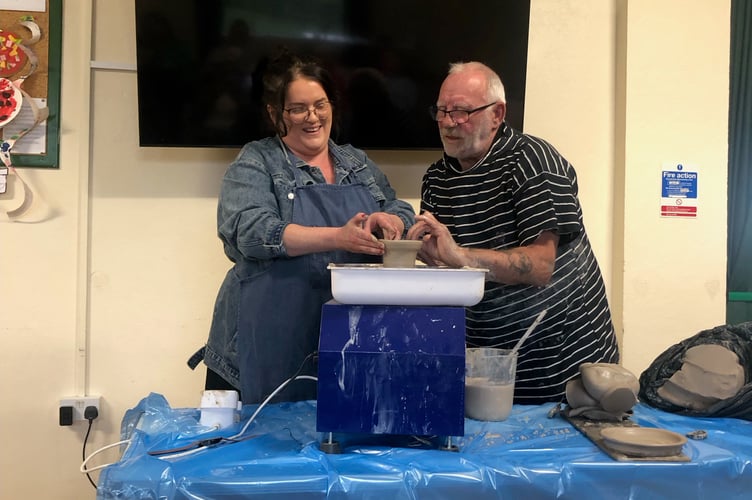 Ben McManigan a local potter helping a member of South Hill Women's Institute learn the art of pot throwing