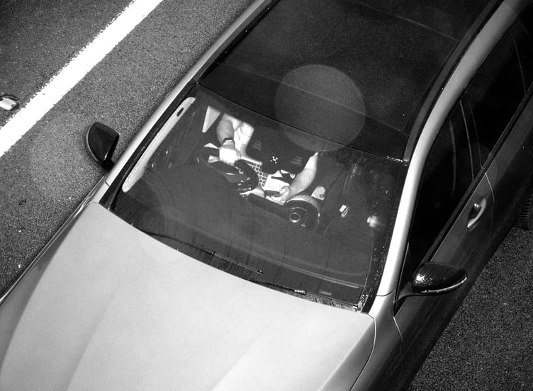 An image captured by the Acusensus camera system showing a driver using a laptop and mobile phone behind the wheel. (Picture: Devon and Cornwall Police)