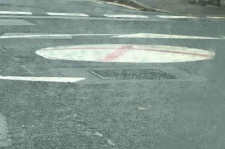 A roundabout in Camborne which is the latest to be daubed with the St George's cross (right)