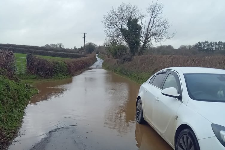A car stranded on Woolacombe Road near Bere Alston during flooding from heavy rain last night.