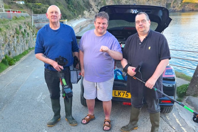 James Mustoe with detectorists David and Den from Cornwall Ring Finders at Porthpean beach.