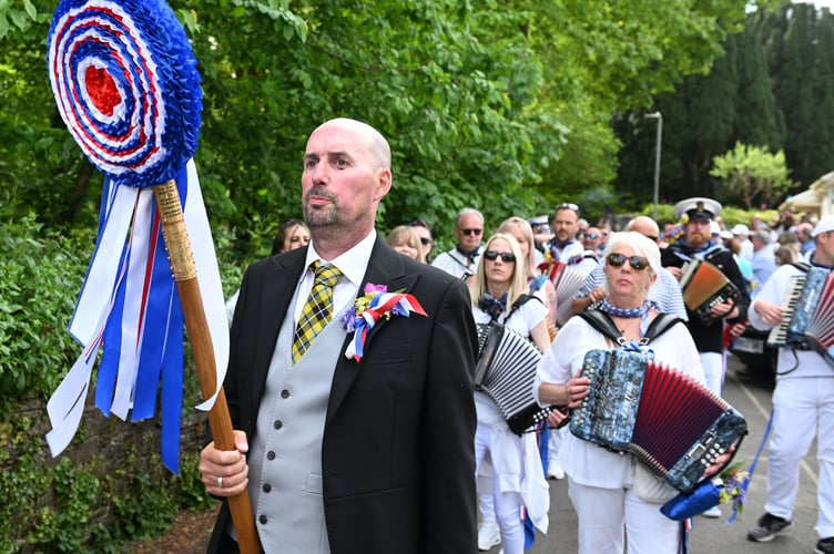 Master of ceremonies Peter Bluett leads the Blue Oss through the streets of Padstow