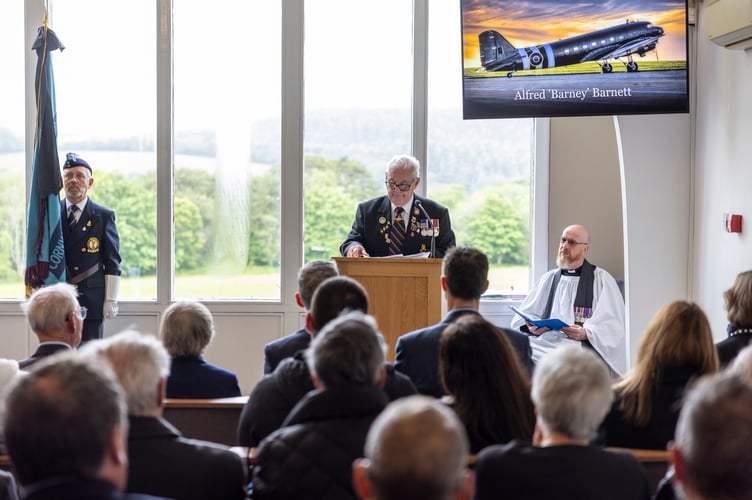 Image shows friend of Barney, Gerald, giving a eulogy. Royal Air Force St Mawgan today joined the wider community in paying tribute toAlfred âBarneyâ Barnett, a distinguished Second World War RAF veteran, whosefuneral took place at Glynn Valley Crematorium, Bodmin at 1130 hrs.Aged 104, Barney lived an extraordinary life of service. Enlisting in 1941 as an AirGunner and later commissioned in 1943, he flew 80 combat sorties over Germanyduring the Second World War. He went on to serve with the elite Pathfinder Force,responsible for marking targets ahead of the main bomber stream, before latertraining as a pilot.Following his commission, Barney served at RAF St Mawgan on four occasionsbetween late 1952 and early 1956, retiring from Service in mid-1959.Todayâs service, officiated by the Station Padre, Squadron Leader Colin OâDell, wasattended by a wide cross-section of the community, including serving personnel,veterans, and Royal Navy and Royal Air Force Air Cadets. Senior stationrepresentatives in attendance included Station Commander Wing CommanderGareth Elliott and Station Warrant Officer Warrant Officer Darrel Keane. The largeand diverse turnout reflected the deep respect held for Barney and his generation.In accordance with his wishes, and in the absence of surviving family, close friendsentrusted his medals and flying logbooks to RAF St Mawgan. His medals, hat and one of his logbooks were used to dress the coffin, ensuring a fitting and personaltribute. The Royal Air Force will preserve his legacy in line with these wishes.