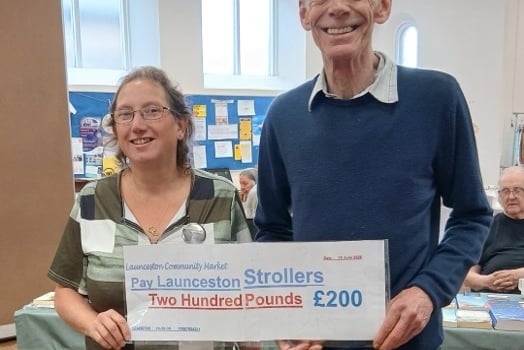 Kay Roberts from Launceston Strollers receiving the cheque from Paul Jellyman from the Launceston Community Market