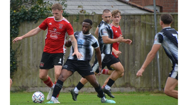 Right-back Jeff Anglia gets his foot in on Kieran Prescott.
