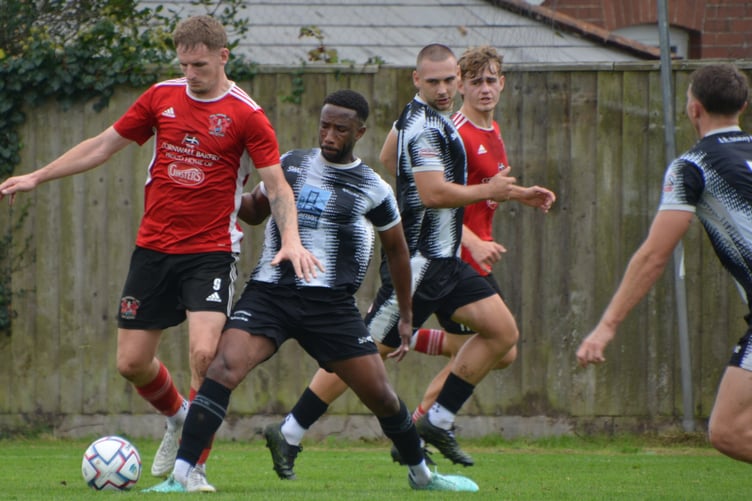 Right-back Jeff Anglia gets his foot in on Kieran Prescott.